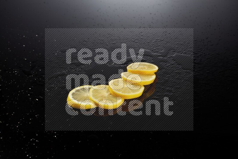 Lemon slices with water drops, and droplets on black background