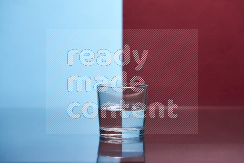 The image features a clear glassware filled with water, set against light blue and dark red background