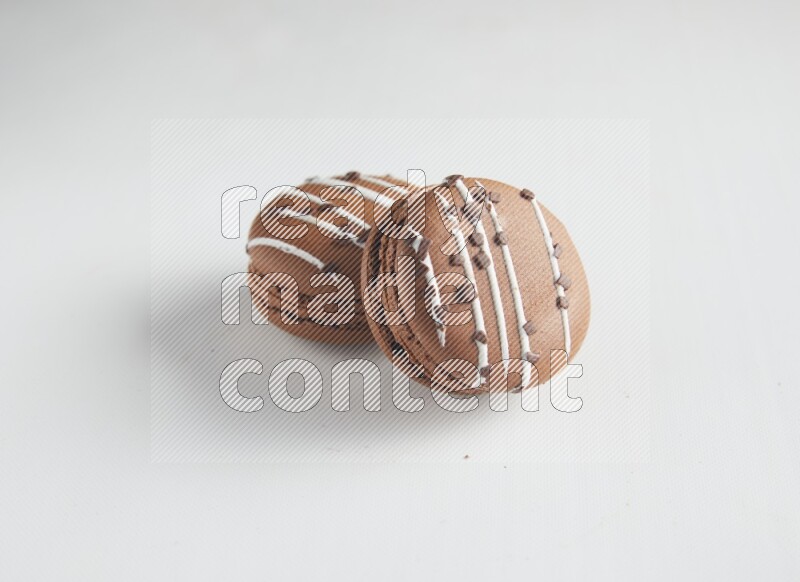 45º Shot of two Brown white Chocolate Caramel macarons on white background
