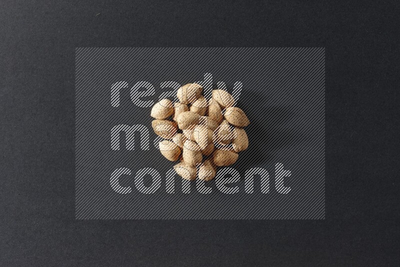 A bunch of almonds on a black background in different angles