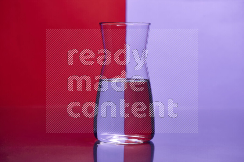 The image features a clear glassware filled with water, set against red and light purple background