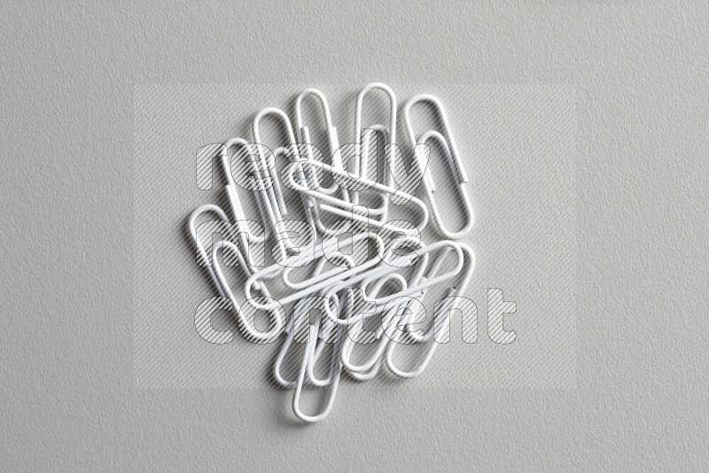 White paperclips isolated on a grey background