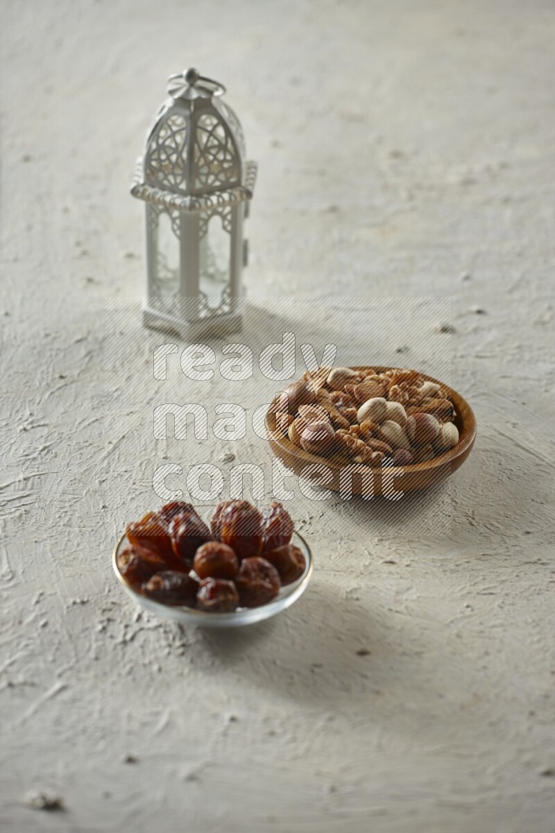 A white lantern with different drinks, dates, nuts, prayer beads and quran on white background