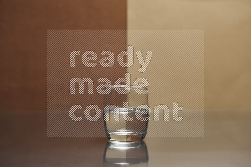 The image features a clear glassware filled with water, set against brown and beige background