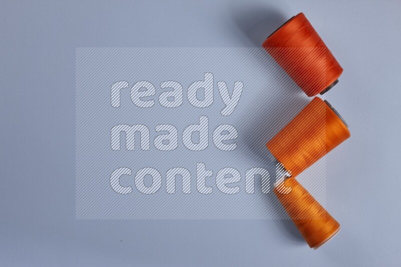 مجموعة من أدوات الخياطة والتفصيل برتقالية اللون على خلفية زرقاء