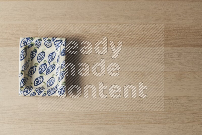 صحن فخاري مزخرف على خلفية خشبية فاتحة