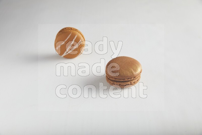 45º Shot of of two assorted Brown Irish Cream, and Brown Coffee macarons  on white background