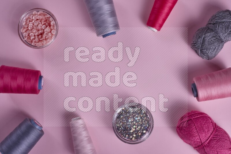 مجموعة من أدوات الخياطة والتفصيل رمادية اللون على خلفية زهرية