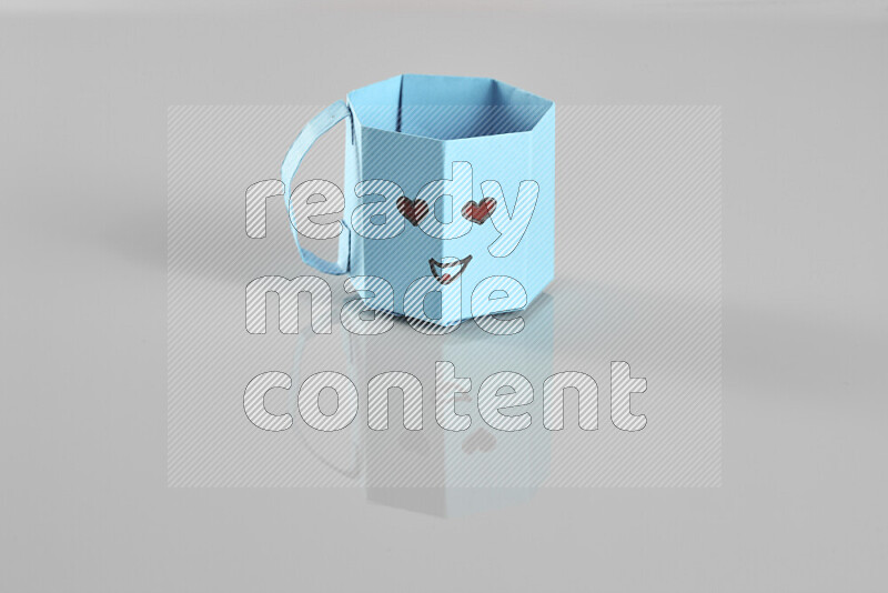 Origami cup on grey background