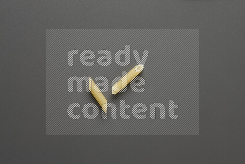 Mini penne pasta on grey background