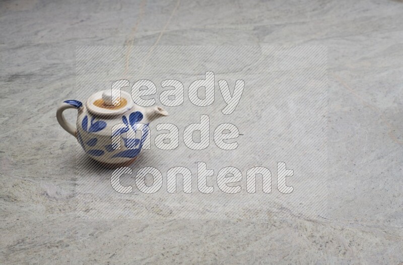 A pottery teapot on grey marble background