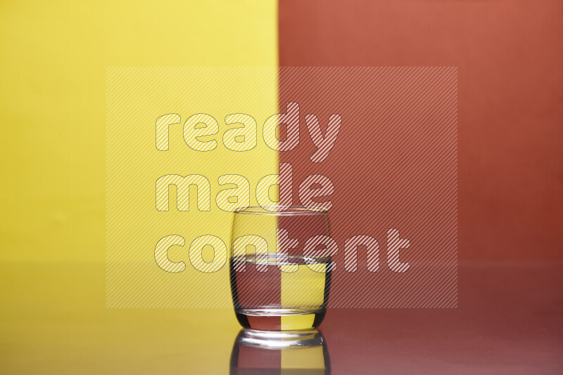 تظهر الصورة أواني زجاجية ممتلئة بالماء موضوعة على خلفية من اللونين الأصفر والبرتقالي الغامق