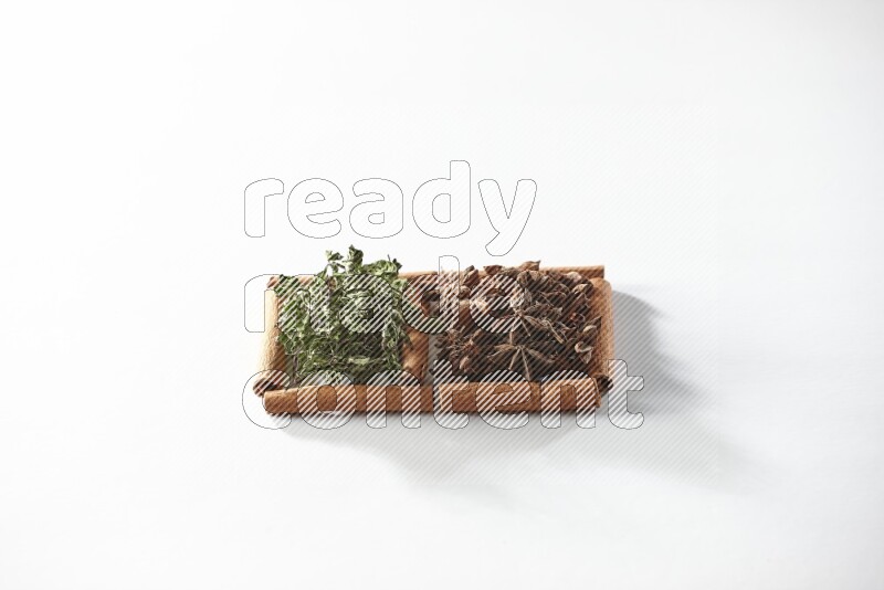 مربعان من أعواد القرفة ممتلئان باليانسون النجمي والنعناع المجفف علي خلفية بيضاء