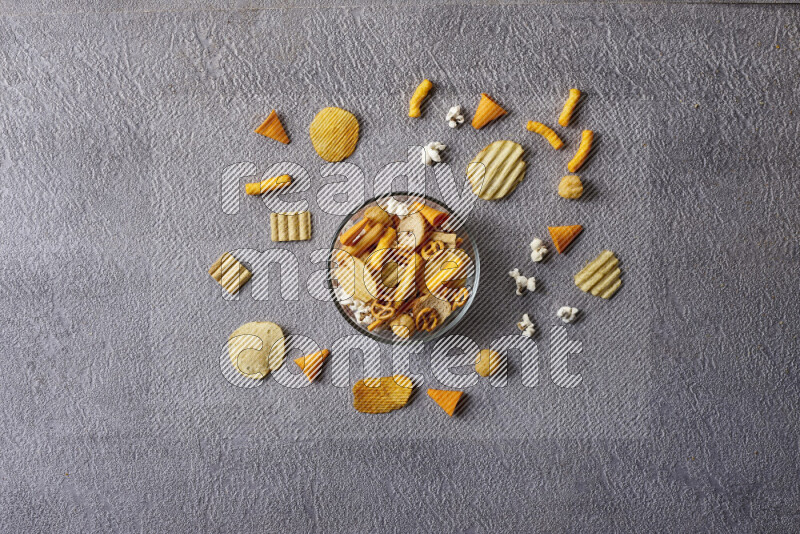 Assorted snacks in pottery bowls on grey background