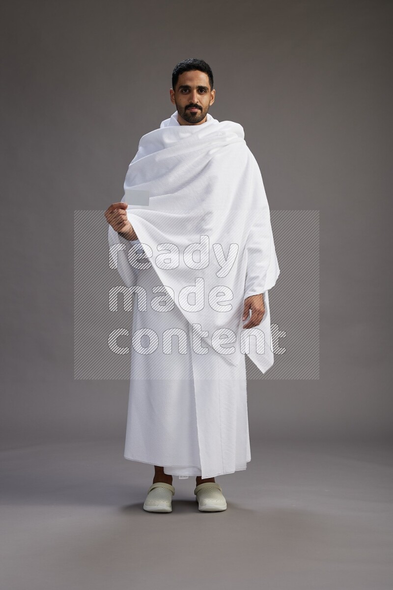A man wearing Ehram Standing holding ATM card on gray background
