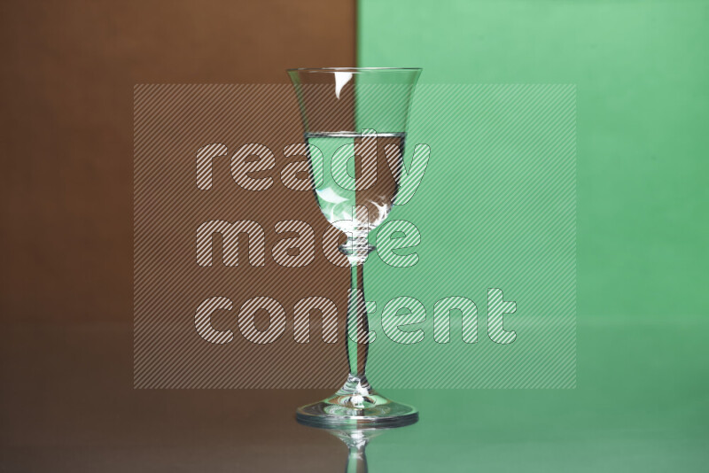The image features a clear glassware filled with water, set against brown and green background