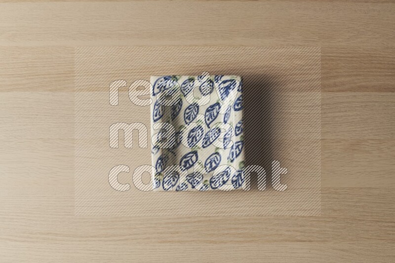 صحن فخاري مزخرف على خلفية خشبية فاتحة