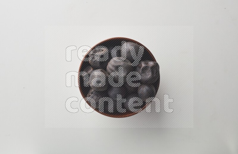 Top-view shot of dried lime (loomi) in a container on white background