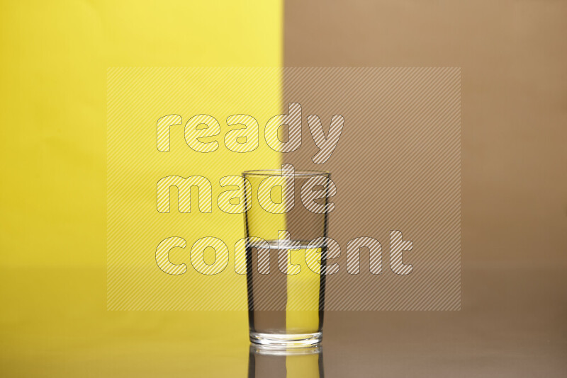 The image features a clear glassware filled with water, set against yellow and beige background