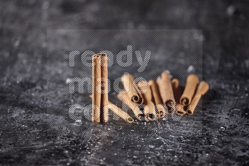 Cinnamon sticks on a textured black background