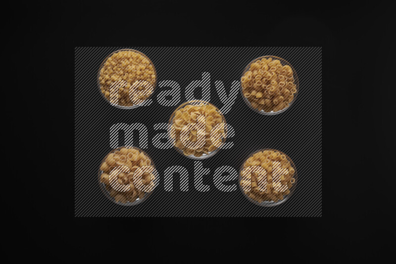 أنواع مختلفة من المعكرونة في أوعية زجاجية علي خلفية سوداء