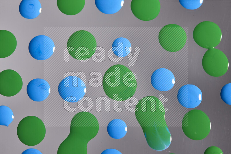 Close-ups of abstract blue and green paint droplets on the surface