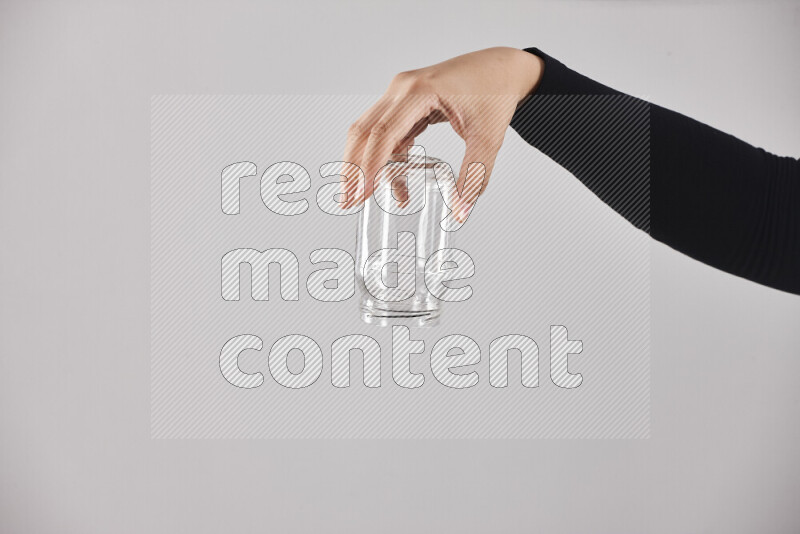 امرأة ترتدي عباءة سوداء تحمل أدوات زجاجية مختلفة في أوضاع متعددة