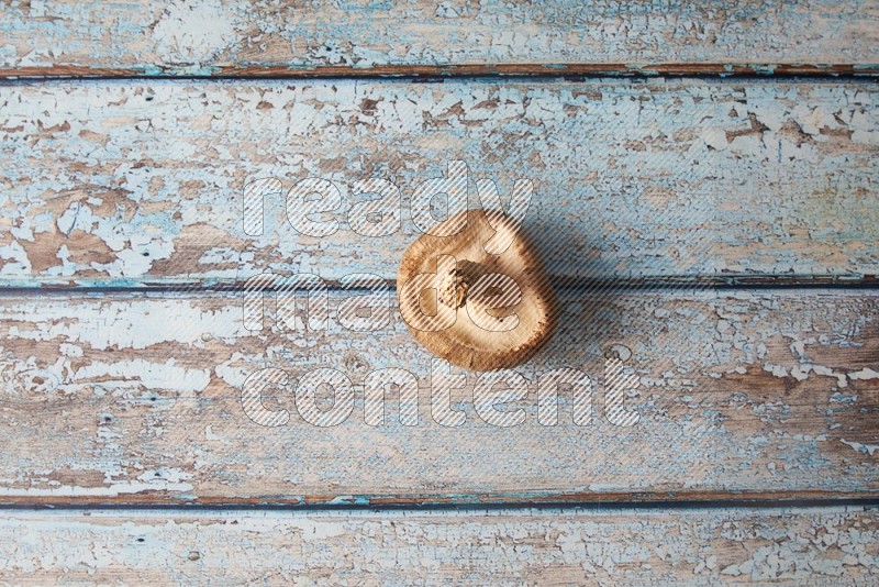 fresh shiitake Mushrooms topview on a light blue wooden textured background