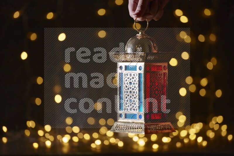 A traditional ramadan lantern surrounded by glowing fairy lights in a dark setup