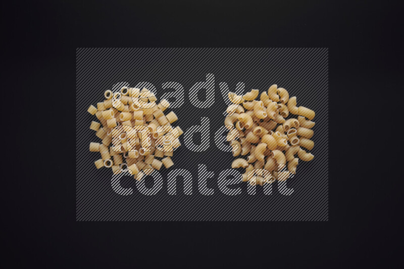 Different pasta types in bunches on black background