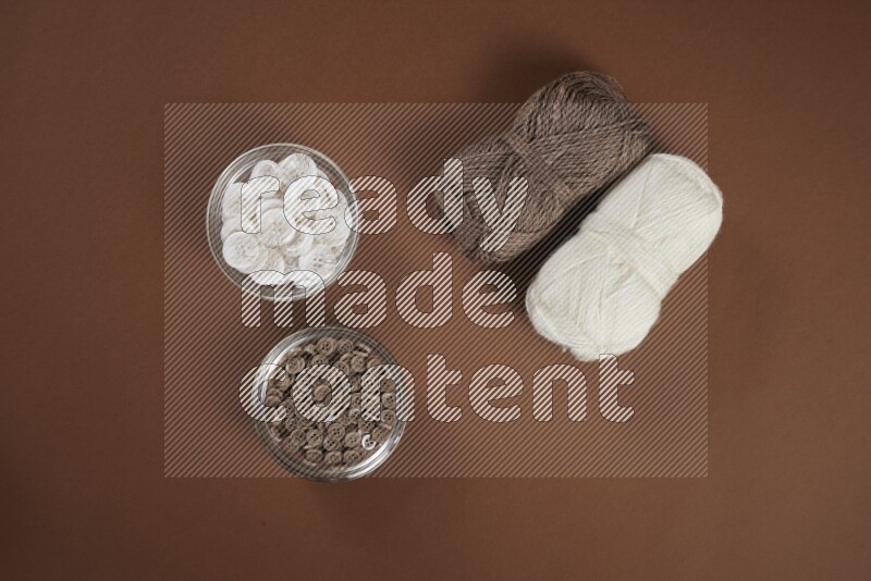 A white and brown collection of sewing and tailoring tools arranged on a brown background