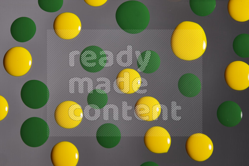 Close-ups of abstract yellow and green paint droplets on the surface