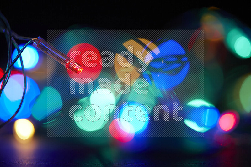 Light bulbs glowing against backdrop of multicolord bokeh