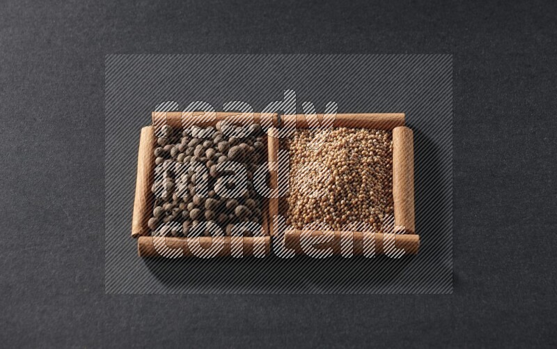 2 squares of cinnamon sticks full of mustard seeds and allspice on black flooring