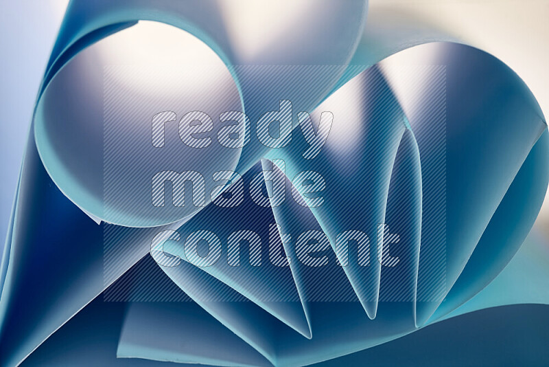 An artistic display of paper folds creating a harmonious blend of geometric shapes, highlighted by soft lighting in blue tones