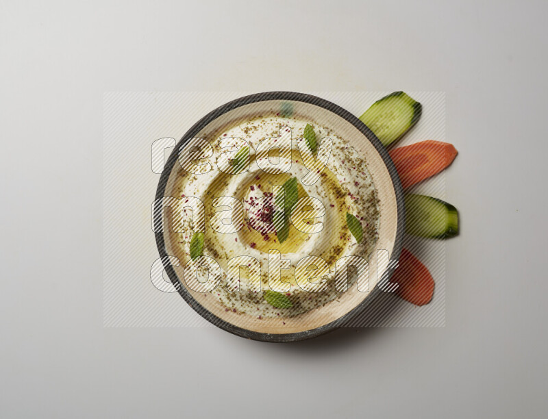 Lebnah garnished with zaater, mint & sumak in a pottery plate on a white background