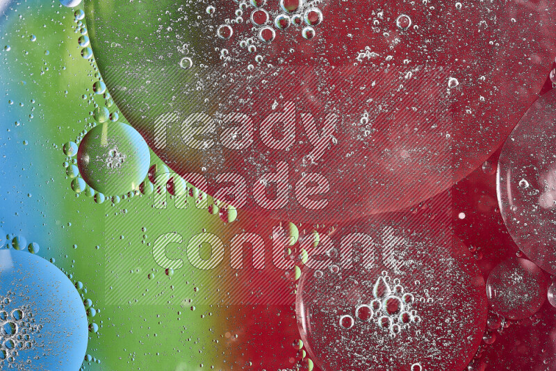 Close-ups of abstract oil bubbles on water surface in shades of red, green and blue