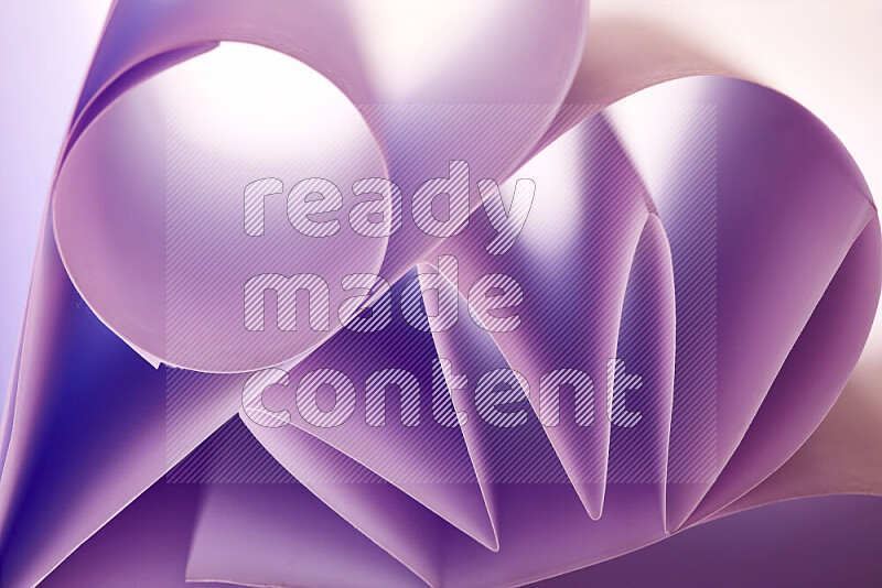 An artistic display of paper folds creating a harmonious blend of geometric shapes, highlighted by soft lighting in purple tones