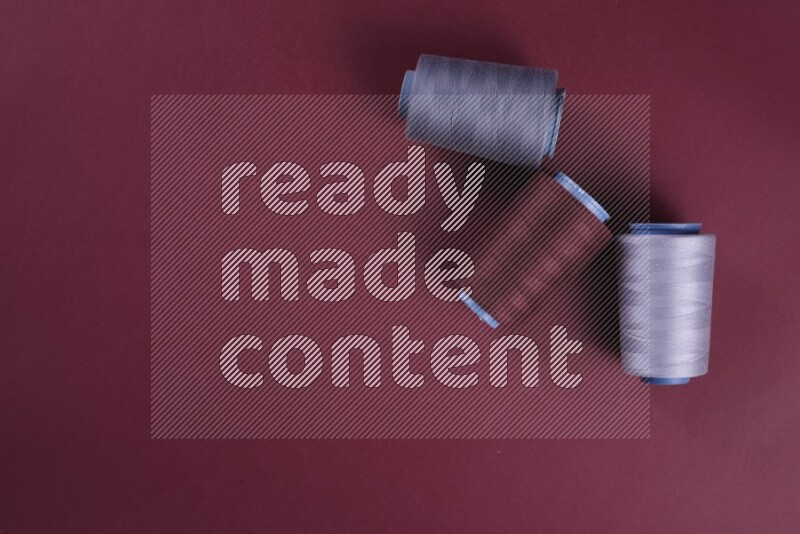 A grey collection of sewing and tailoring tools arranged on a red background