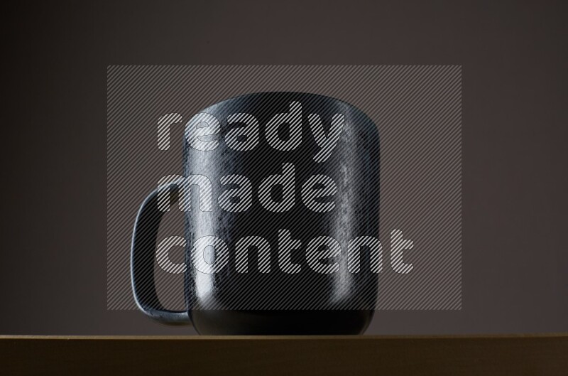Low angle shot of a black cup on grey background