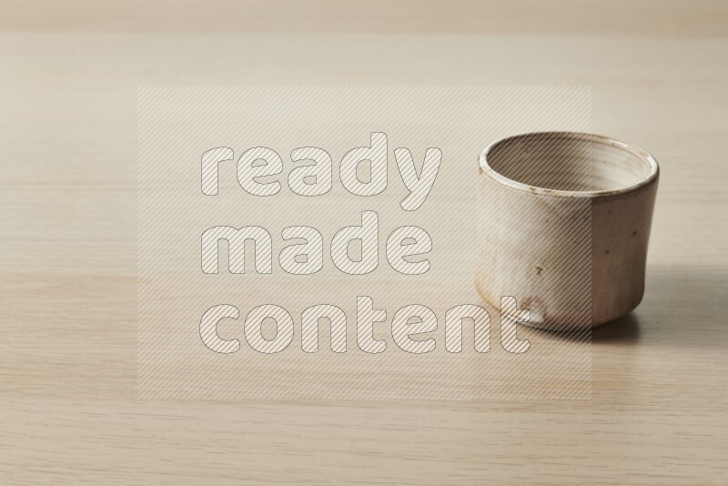 A pottery cup on light wooden background
