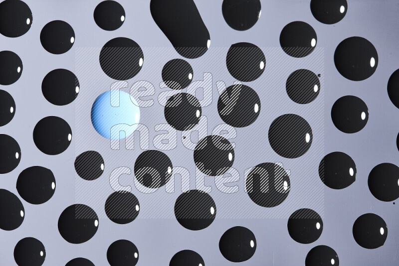 Close-ups of abstract blue and black paint droplets on the surface