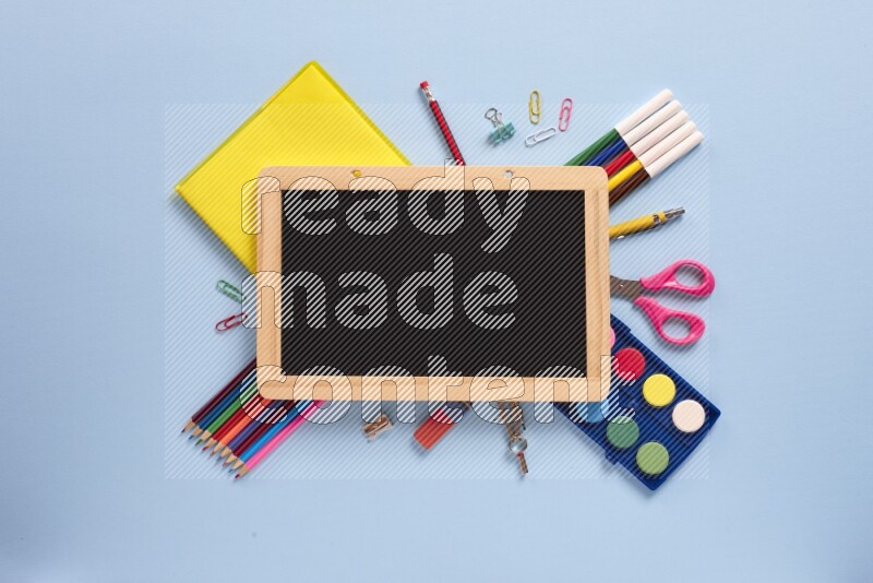 A blackboard with assorted school supplies on blue background