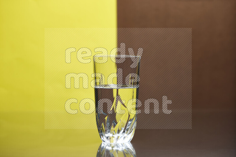 تظهر الصورة أواني زجاجية ممتلئة بالماء موضوعة على خلفية من اللونين الأصفر والبني