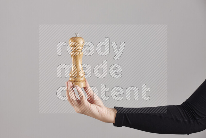 امرأة ترتدي عباءة سوداء تحمل أدوات خشبية مختلفة في أوضاع متعددة