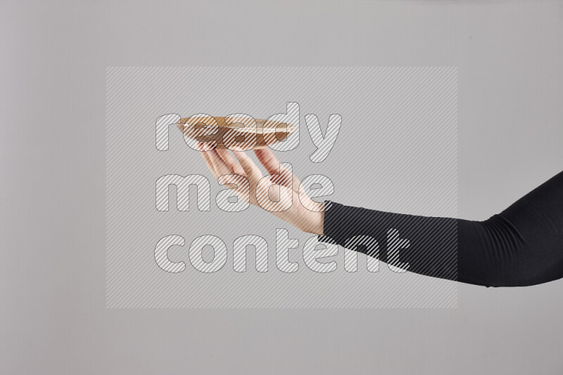 A woman in black abaya holding different pottery essentials in different positions