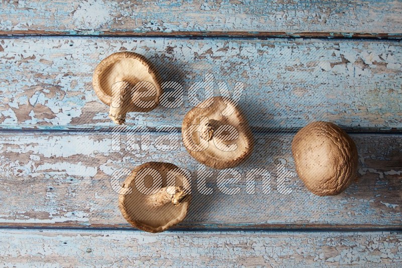 fresh shiitake Mushrooms topview on a light blue wooden textured background