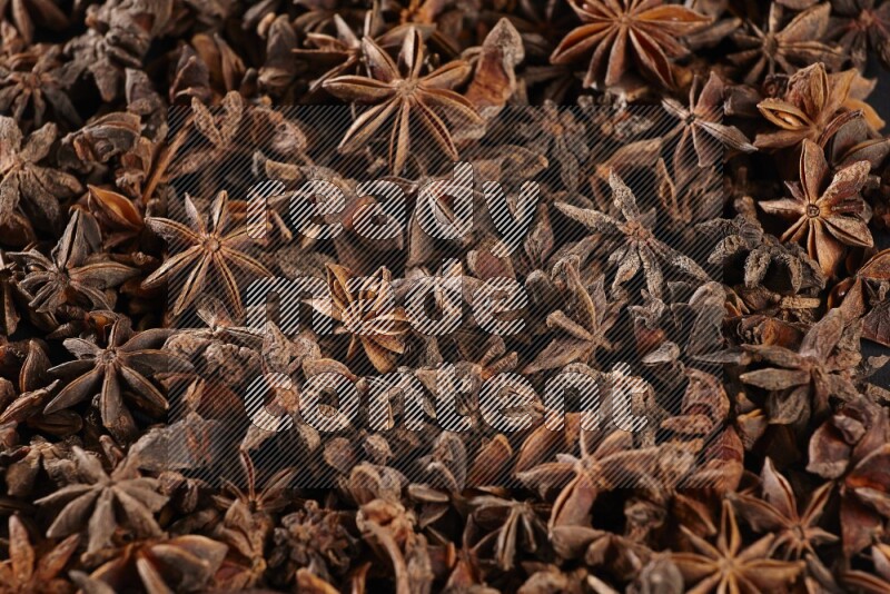 Star Anise herbs fill the frame on black flooring