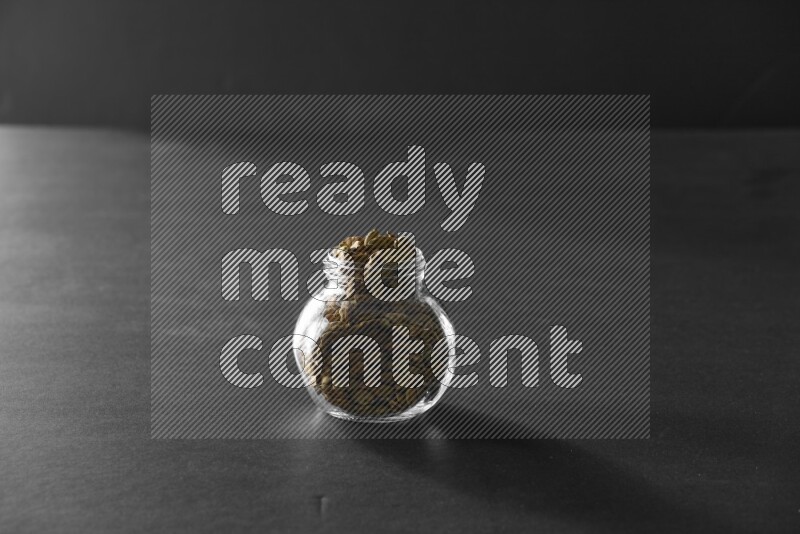 هيل في وعاء زجاجي علي خلفية سوداء