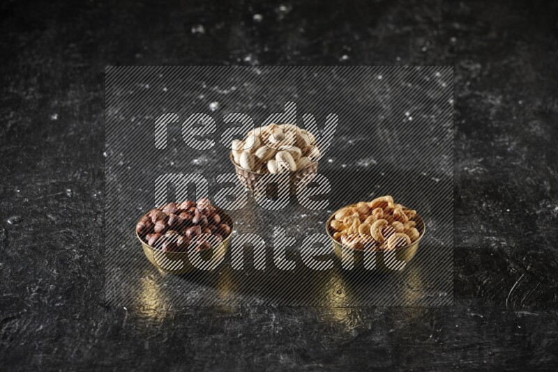 مكسرات في وعاء معدني علي خلفية سوداء